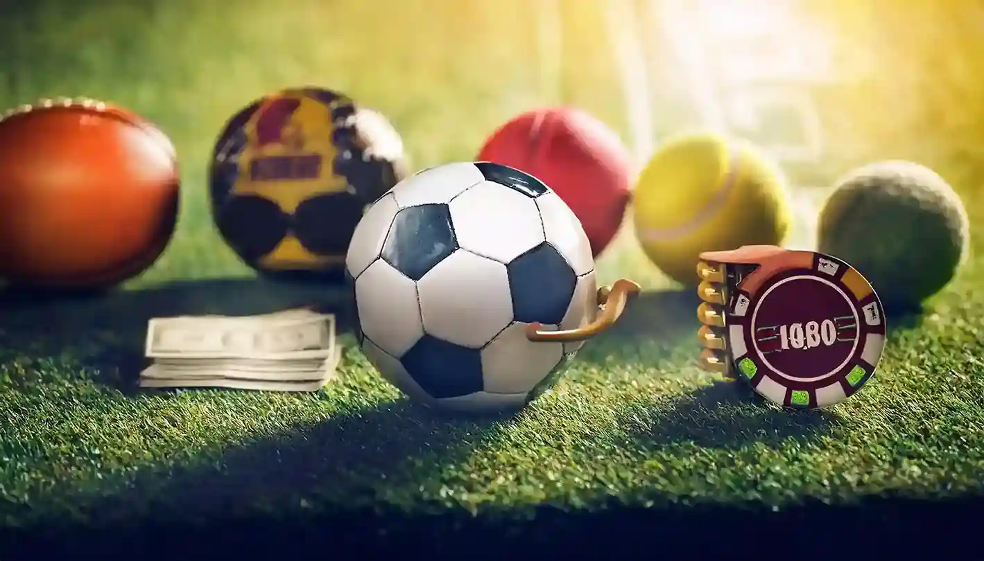Football tennis and other sports balls on grass beside cash and a casino chip